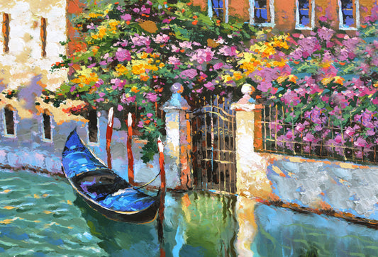 A scenic view of a city canal in Venice, Italy, adorned with elegant gondolas gliding gracefully through the tranquil waters. Historic buildings with colorful facades line the canal, creating a picturesque backdrop against the clear blue sky. The gondoliers expertly navigate their boats, offering a quintessential Venetian experience to passengers. This charming scene captures the timeless allure and romantic ambiance of Venice's iconic waterways