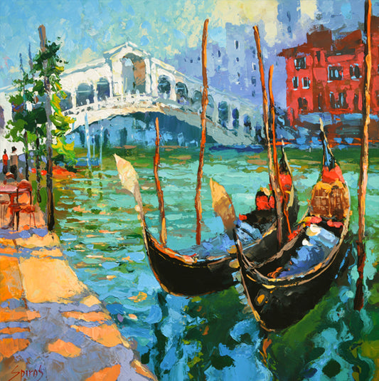 A scenic view of a city canal in Venice, Italy, adorned with elegant gondolas gliding gracefully through the tranquil waters. Historic buildings with colorful facades line the canal, creating a picturesque backdrop against the clear blue sky. The gondoliers expertly navigate their boats, offering a quintessential Venetian experience to passengers. This charming scene captures the timeless allure and romantic ambiance of Venice's iconic waterways